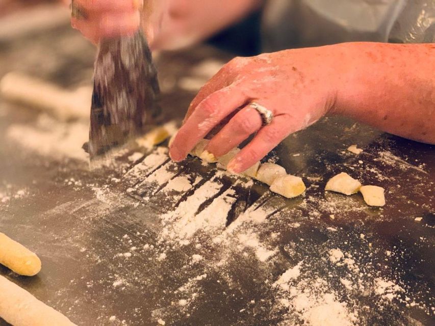 A cook trimming ribbons of egg dough on a flour-dusted worktop